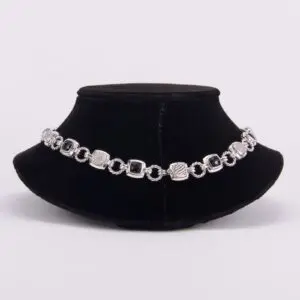 Silver bracelet on black velvet display stand.
