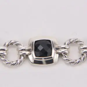 Silver bracelet with black stone centerpiece.
