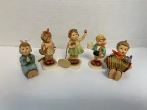 Five ceramic figurines of children in poses.