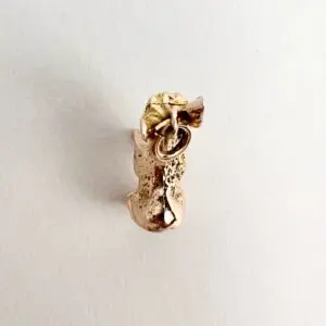 Gold cat-shaped earring with textured surface.