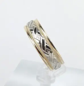 Two-tone ring with intricate braided design.