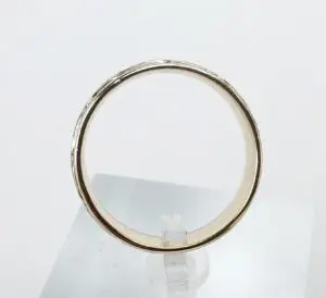 Gold ring on a clear stand.