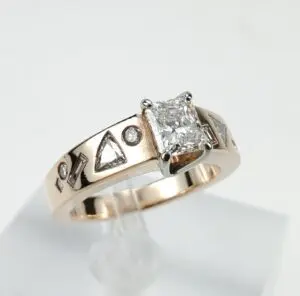Gold ring with square diamond and symbols.