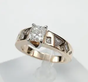 Gold ring with diamond and geometric designs.