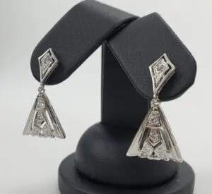 Silver geometric earrings on display stand.
