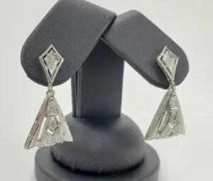 Silver geometric earrings on display stand.