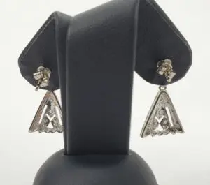 Silver triangular earrings on display stand.