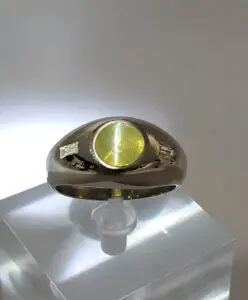 Gold ring with yellow gemstone on display.