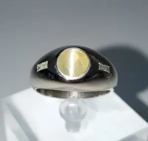 Silver ring with yellow gemstone centerpiece.