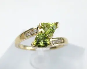 Gold ring with green gemstones and diamonds.