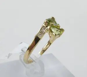 Gold ring with green gemstone and diamonds.