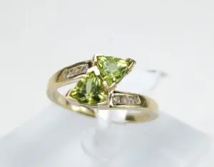 Gold ring with green gemstones and diamonds.