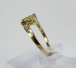 Gold ring with green gemstone on display.