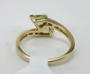 Gold ring with green gemstone, side view.