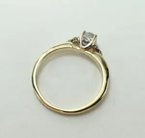 Gold ring with a diamond on top.