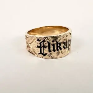 Gold ring with engraved black lettering.