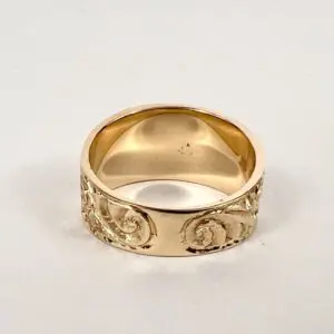 Gold ring with intricate engraved design.