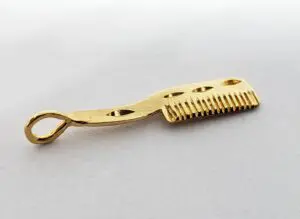 Golden comb with decorative handle design.