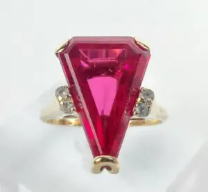 Gold ring with large red gemstone.