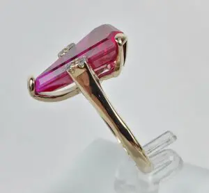 Gold ring with pink gemstone side view.