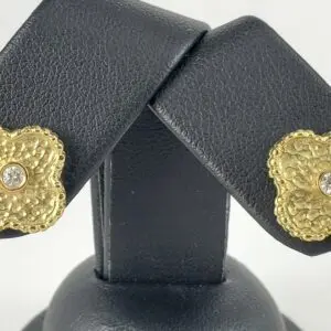 Gold textured earrings with central gemstones.
