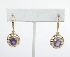 Gold earrings with purple stones displayed.