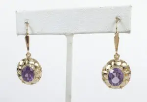 Gold earrings with purple gemstones displayed.