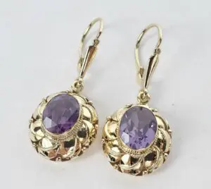 Gold earrings with purple gemstones.