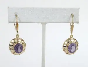 Gold earrings with purple gemstones displayed.