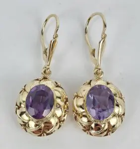 Gold earrings with purple gemstones.