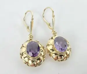 Gold earrings with purple gemstones.