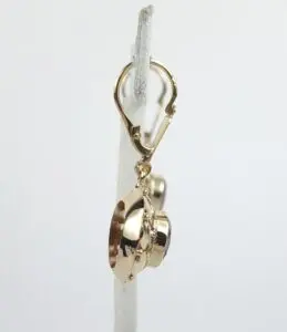 Gold spaceship charm on earring hoop.