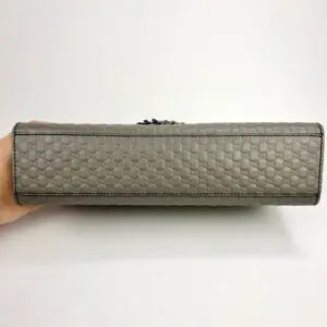 Beige textured handbag displayed horizontally.