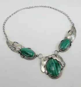 Silver necklace with green stone accents.
