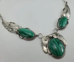 Silver necklace with green stone embellishments.