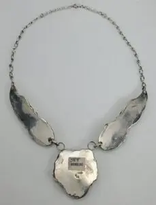 Silver necklace with three abstract shapes.