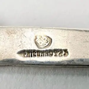 Silver object with engraved hallmark and text.