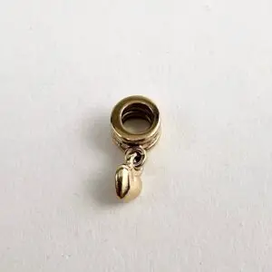 Gold charm with a small dangling bead.