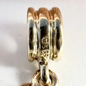 Gold ring with engraved markings and chain.