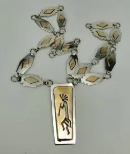 Silver necklace with geometric and figure designs.