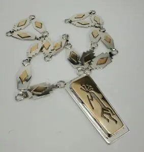 Silver and gold necklace with geometric designs.