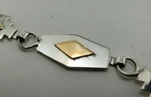 Geometric silver bracelet with gold diamond shape.
