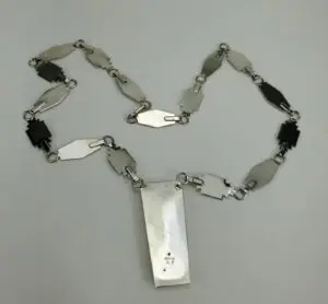 Geometric metal necklace on white background.