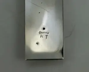 Rectangular metal object with "Sterling RT" engraving.