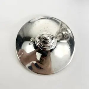 Silver lid with reflective surface on white.
