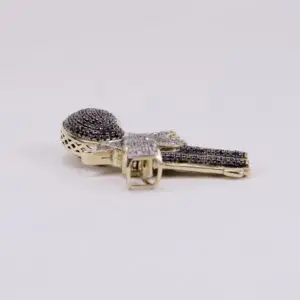 Gold microphone-shaped pendant with black stones.
