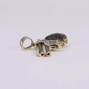 Gold gun-shaped pendant with black stones.