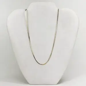 Gold chain on a white display stand.