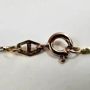 Gold bracelet clasp on a white background.