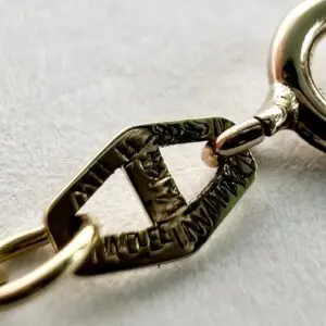 Gold chain clasp with engraved details.